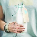 young-woman-holding-bottle-of-dairy-free-almond-PEYHRSZ.jpg